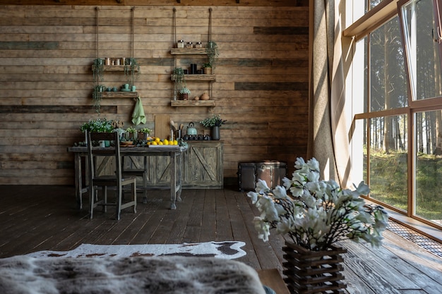 Foto interior oscuro y acogedor de la gran casa de madera, muebles de madera y pieles de animales. gran ventanal y techo muy alto.