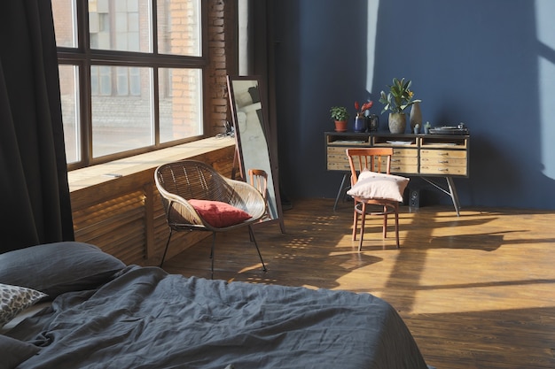 Interior oscuro de un apartamento estudio de estilo loft de planta abierta enorme, moderno y elegante, con columnas y techos altos.