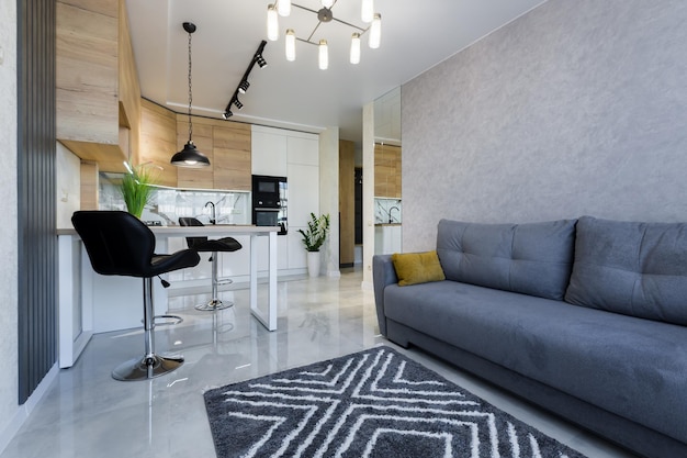 Interior de un pequeño apartamento, sofá azul en la cocina del estudio de la sala de estar