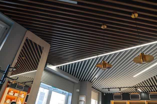 El interior de un restaurante o cafetería Hermoso diseño de techo en un nuevo apartamento alquilado Revestimiento de madera en el techo y grandes lámparas redondas