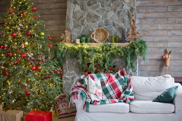 Interior rústico de Navidad con sofá blanco Árbol de Navidad con adornos verdes y rojos