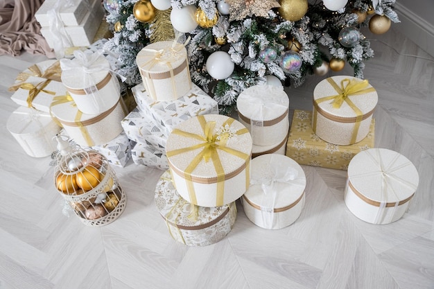 Interior de la sala de estar con un árbol de Navidad y decoraciones Hermoso árbol de Navidad con decoración festiva de oro blanco Concepto de Navidad y Año Nuevo presentes cajas y regalos