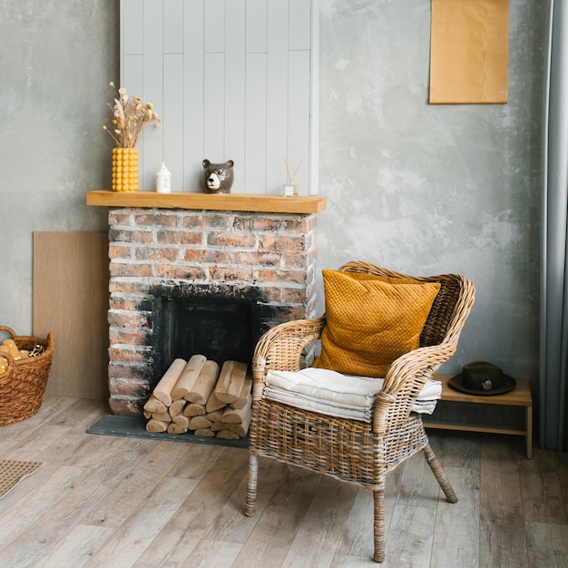 El interior de la sala de estar en una casa de campo Acogedora chimenea y silla de mimbre.