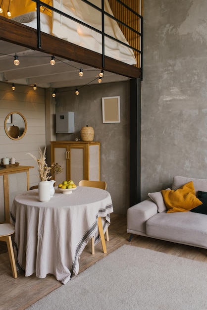 Interior de una sala de estar escandinava con una mesa de comedor redonda y un sofá gris