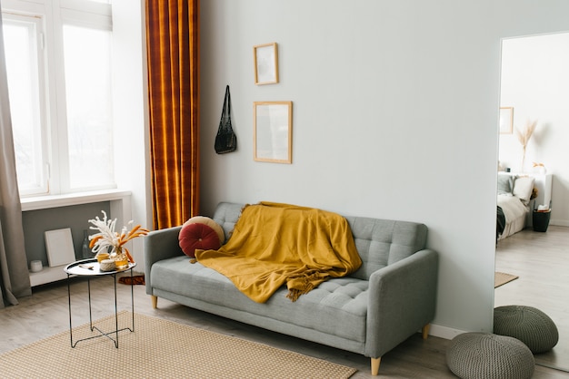 Interior de la sala de estar en un estilo minimalista escandinavo en colores gris-amarillo-naranja