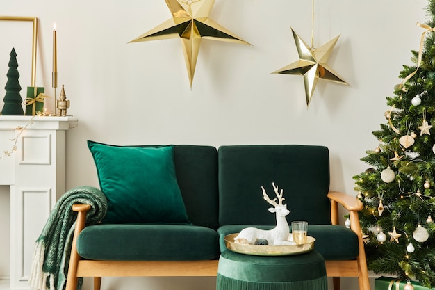 Interior de la sala de estar de Navidad con estilo con sofá verde, chimenea blanca, árbol de Navidad y corona, estrellas, regalos y decoración. Tiempo familiar. Plantilla.