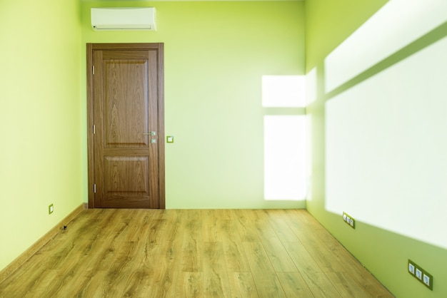 Interior de la sala de estar verde habitación vacía con puerta y piso de madera