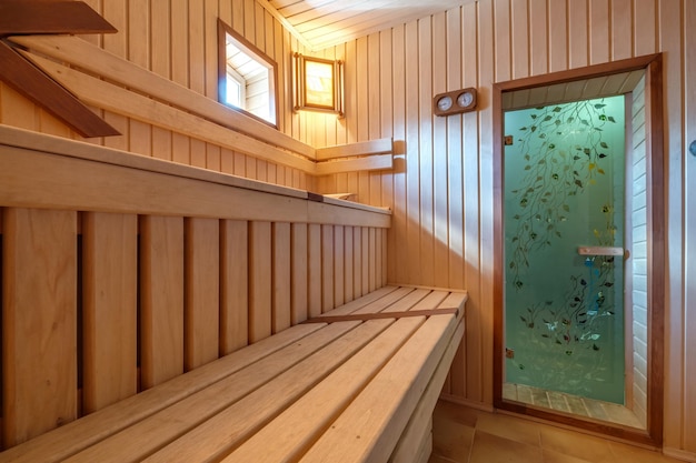 Interior de sauna de baño ruso de madera clásico de diseño estándar con piedras calientes