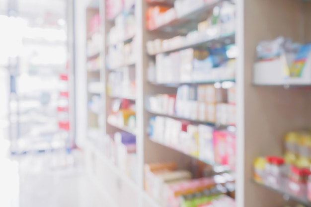 El interior de la tienda de farmacia con medicamentos, vitaminas, suplementos alimenticios y productos sanitarios de venta libre en los estantes médicos difumina la farmacia para el fondo