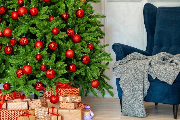 Interior de vacaciones Hermoso árbol de navidad decorado con sillón azul