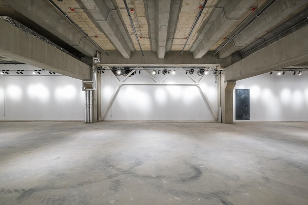 Interior vazio da grande sala de concreto como armazém ou hangar com holofotes