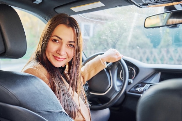 Interior del vehículo La mujer está sentada en un automóvil moderno de color negro