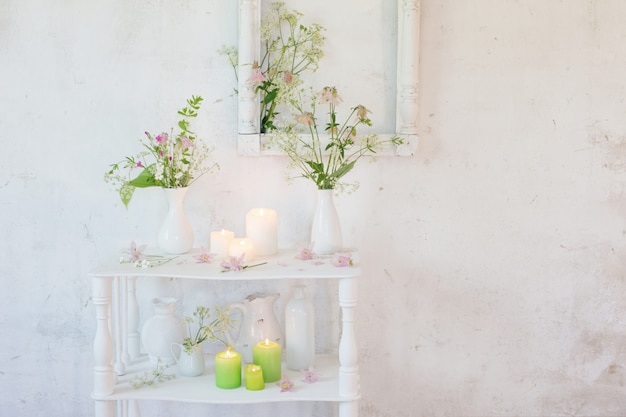 Interior vintage blanco con flores y velas.