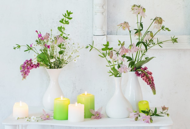 Interior vintage blanco con flores y velas.