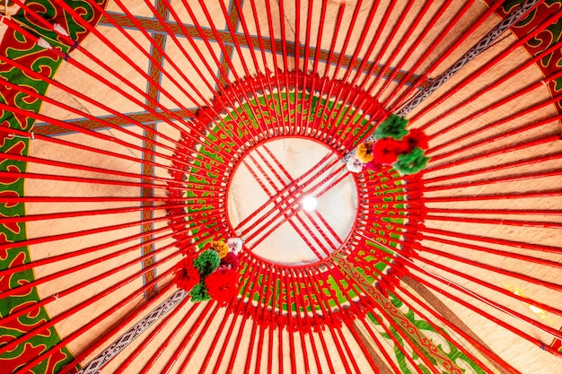 Foto el interior de la yurta shanyrak elemento impotente de la tienda tradicional kirguisa símbolo de tunduk en el centro de kirguistán bandera nacional decoración nacional en el techo bordado y patrones de nómadas de asia central