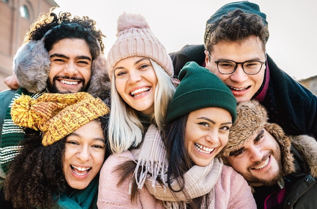 Internationale Jungs und Mädchen, die lustige Selfies auf warmer Mode machen