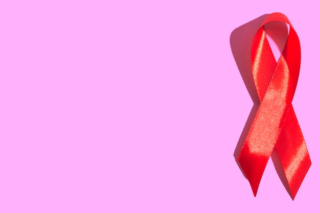 Internationaler AIDS-Tag. Rote Schleife auf einem beigen Hintergrund hautnah. Banner. AIDS-Bewusstseinskonzept. 1. Dezember.