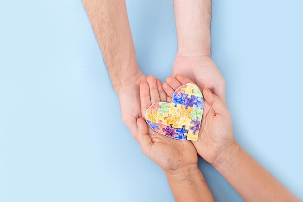 Internationaler Autismus-Bewusstseinstag übergibt zwei Personen, die ein Herz aus Puzzles halten