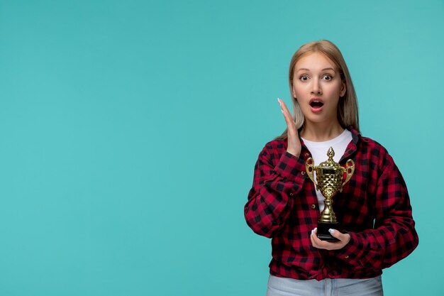 Internationaler Studententag, süßes junges Mädchen in rot kariertem Hemd, super aufgeregt für eine Trophäe