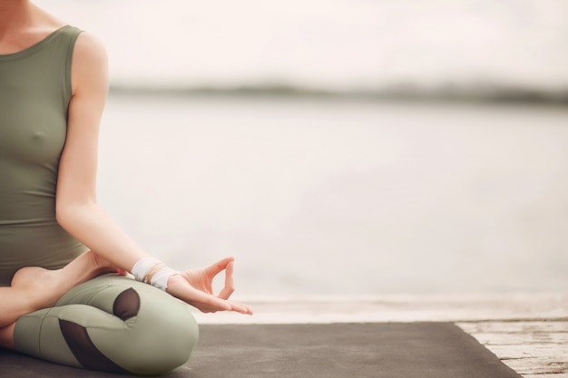 Internationaler Tag des Yoga. Junge Frau, die Hatha Yoga an der Seeküste praktiziert,