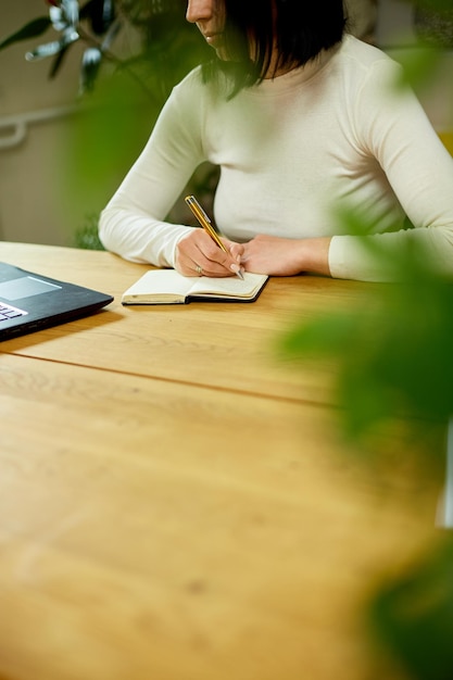 Internet para el aprendizaje y la búsqueda de empleo Mano de mujer haciendo notas en el bloc de notas