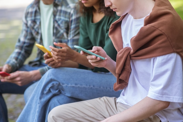 En Internet. Grupo de personas con smratphones sentados en el banco