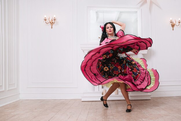 Foto intérprete de danza gitana con un lujoso vestido folclórico