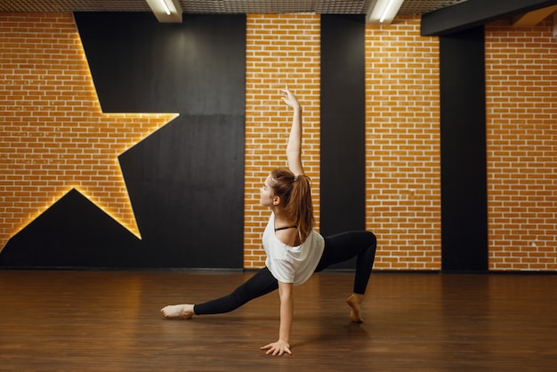 Intérprete de dança contemporânea feminina, flexibilidade corporal. Dançarina fazendo exercícios na aula, balé moderno, dança elegante, exercícios de alongamento