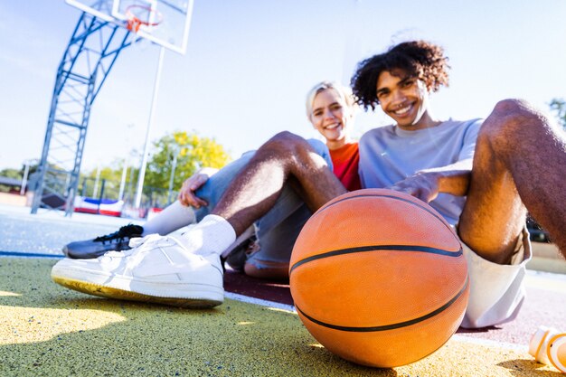 Interracial junge Paare, die sich im Freien verabreden, farbiger und moderner urbaner Hintergrund - Multiethnische Menschen mit stilvoller und cooler urbaner Kleidung, die sich im Freien verbinden