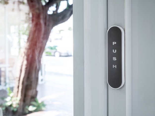 Foto interruptor de activación de botón inalámbrico de color oscuro para la apertura automática de la puerta.