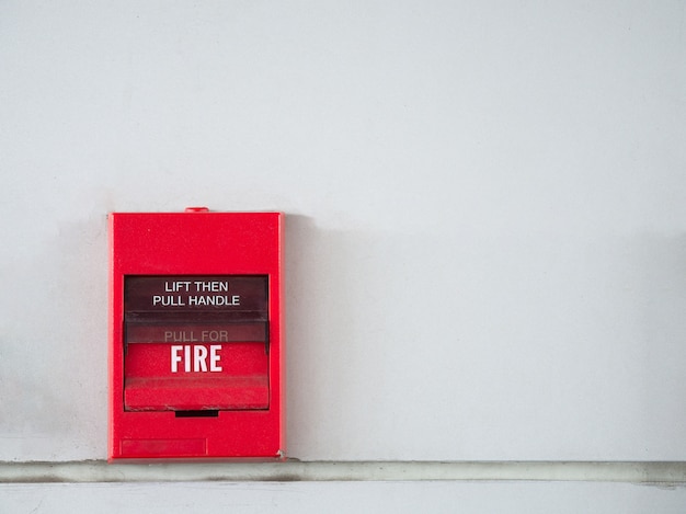 Foto interruptor de botón, alarma de incendio en la pared gris para alarma y sistema de seguridad con extinción de incendios