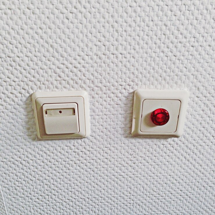 Foto interruptor y botón rojo en la pared blanca