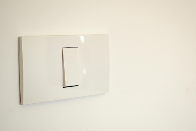 Interruptor de iluminação branco na parede de concreto