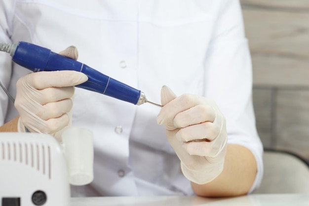 Foto interruptor de manicure profissional na broca de unhas no salão de beleza de unhas