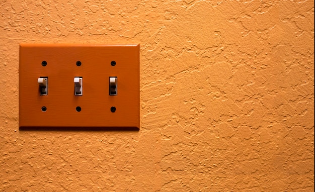 Interruptor eléctrico vintage en pared naranja retro