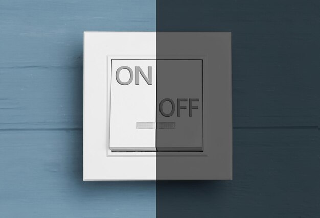 Interruptor de luz encendido y apagado sobre fondo de madera azul