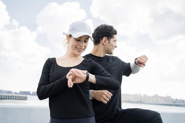 Intervalo, use um relógio de fitness, um jovem casal faz um treino de fitness correndo juntos