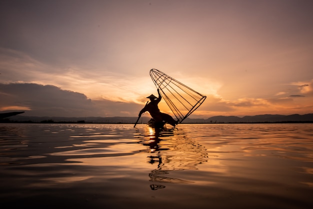 Intha birmanês pescadores no barco captura de peixes tradicionais no lago inle, estado de shan, myanmar