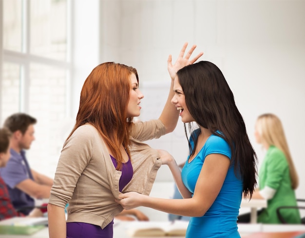 intimidación, escuela, educación, amistad y concepto de personas - dos adolescentes peleando y poniéndose físicos