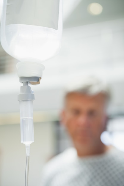 Intravenöser Tropf mit Patienten im Hintergrund