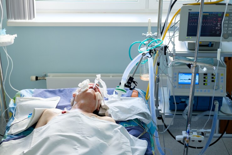 Intubado hombre blanco adulto bajo AVL acostado en coma en el departamento de cuidados intensivos. Paciente en estado crítico.