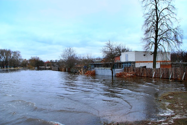 Inundación del río en primavera en la ciudad durante el derretimiento de la nieve Inundación de la ciudad Inundación entre casas privadas Inundación en el río Spring Desastre natural Gran agua en la ciudad