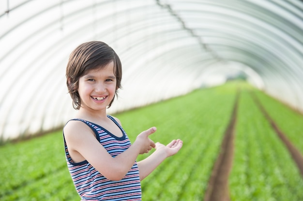 Invernadero para planta y niño en frente