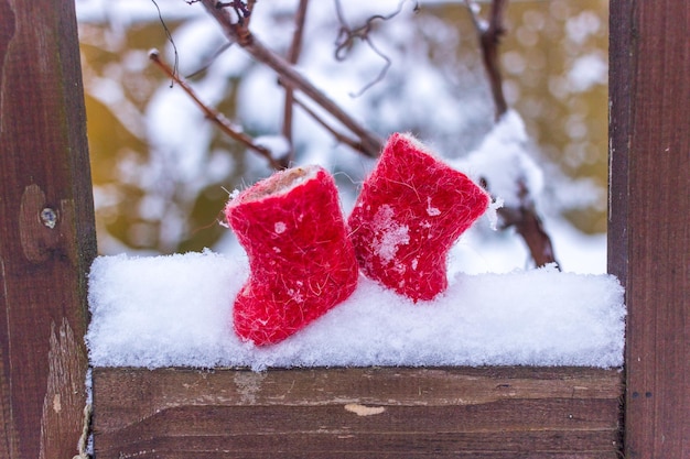 Foto inverno ainda vida pequenas botas vermelhas na neve