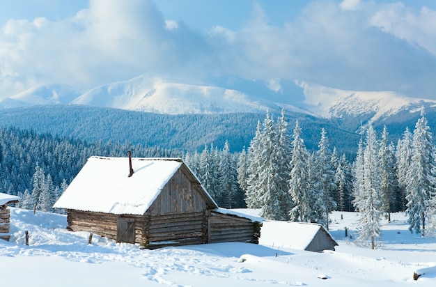 Inverno calmo paisagem montanhosa com galpão e cume do monte atrás