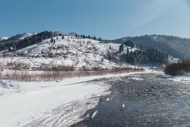 Inverno, dia gelado em uma vila localizada entre as montanhas cobertas de neve nas margens do rio.