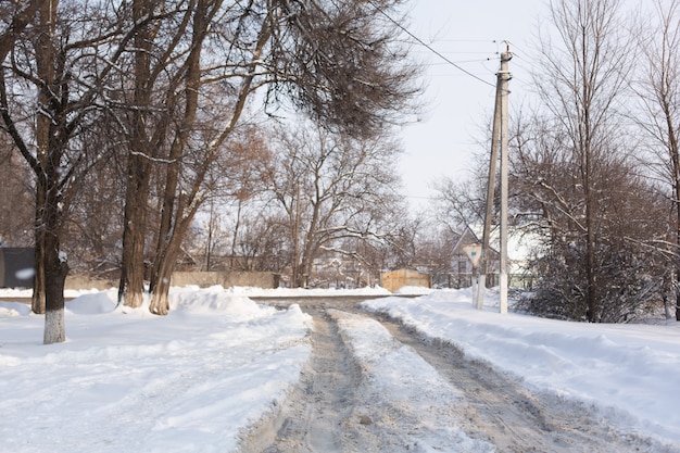 Inverno estrada mal limpa. Estrada no campo repleta de neve. Paisagem do inverno com montes de neve