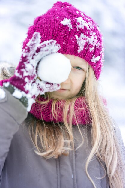 Inverno - garotinha sorridente ao ar livre na hora da queda de neve