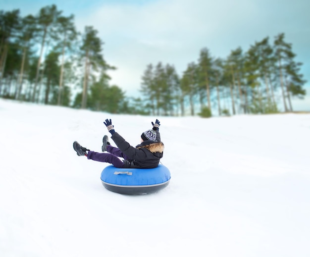 inverno, lazer, esporte e conceito de pessoas - adolescente feliz ou jovem deslizando no tubo de neve