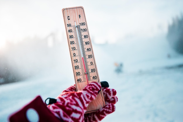 Inverno. Termômetro na neve mostra baixas temperaturas em Celsius ou Fahrenheit.